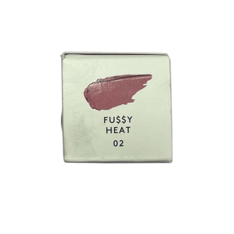 Cosmetic compact with pink shade and 'Fussy Heat 02' text on a light green background